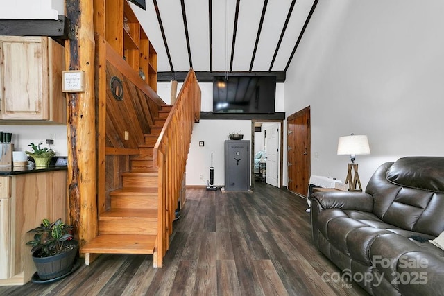living area featuring stairway, dark wood-style flooring, and a towering ceiling