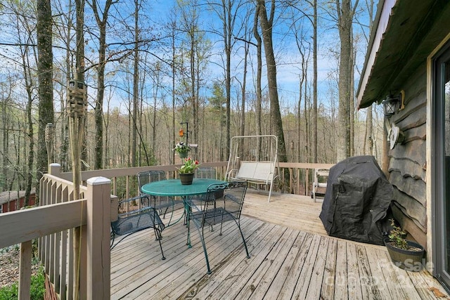 wooden terrace featuring grilling area and outdoor dining area