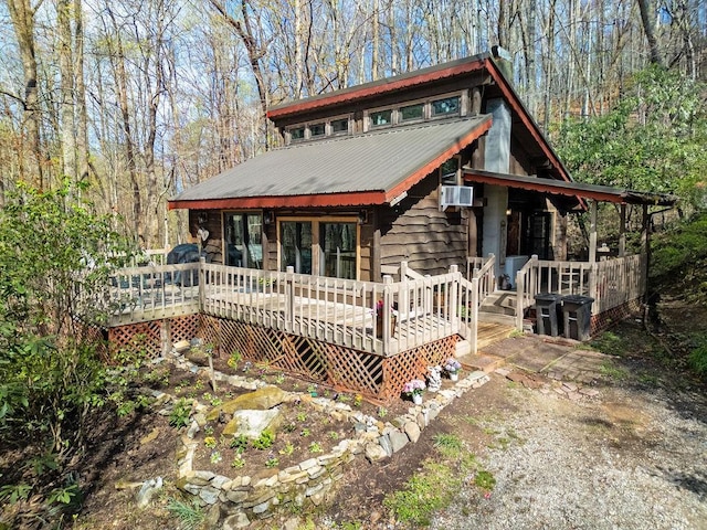 chalet / cabin with a deck, cooling unit, and metal roof