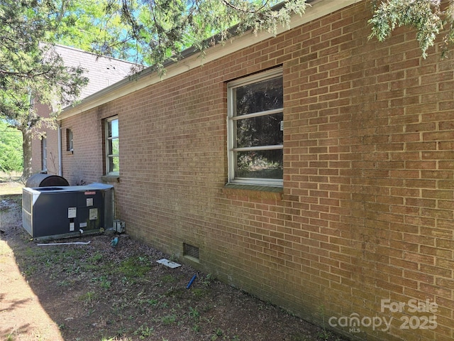 view of side of home featuring brick siding and crawl space