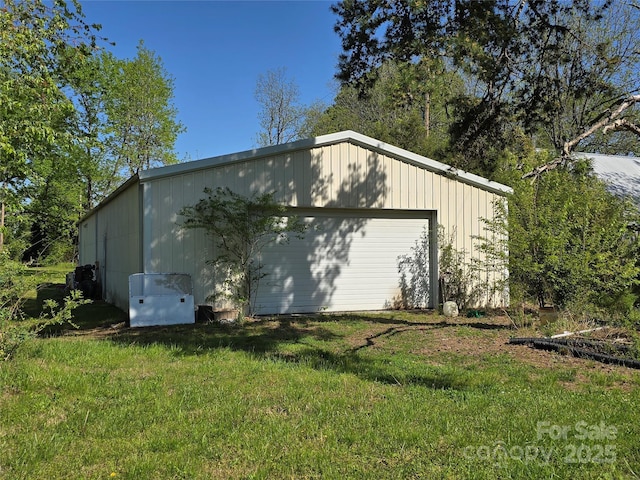 exterior space featuring an outbuilding, a detached garage, and a yard