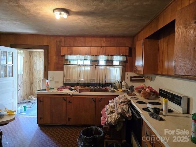kitchen with brown cabinetry, light countertops, and electric range oven