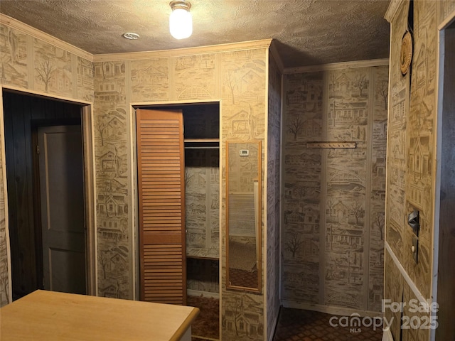 bathroom with ornamental molding and a textured ceiling