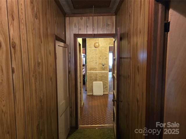 hall with wood walls and carpet floors