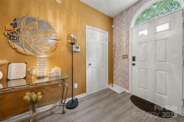 foyer with baseboards and wood finished floors
