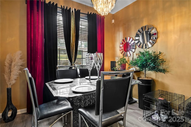 dining room featuring wood finished floors and an inviting chandelier