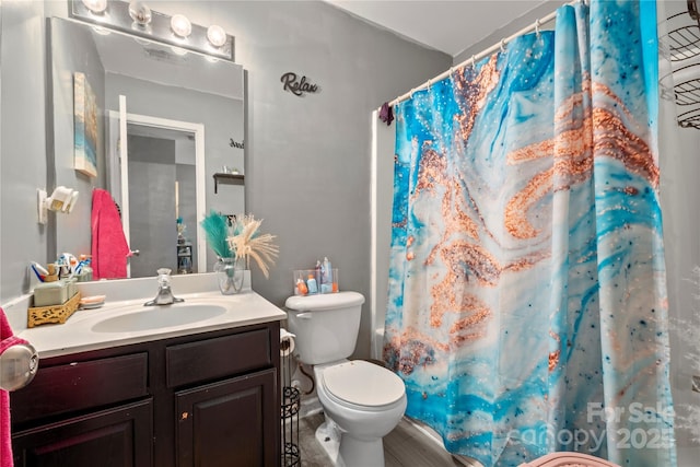 bathroom with a shower with shower curtain, toilet, and vanity