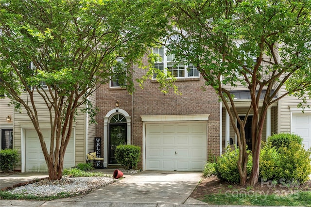 view of front of property with driveway, an attached garage, and brick siding