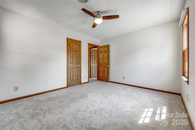 unfurnished bedroom with baseboards, visible vents, ceiling fan, and carpet