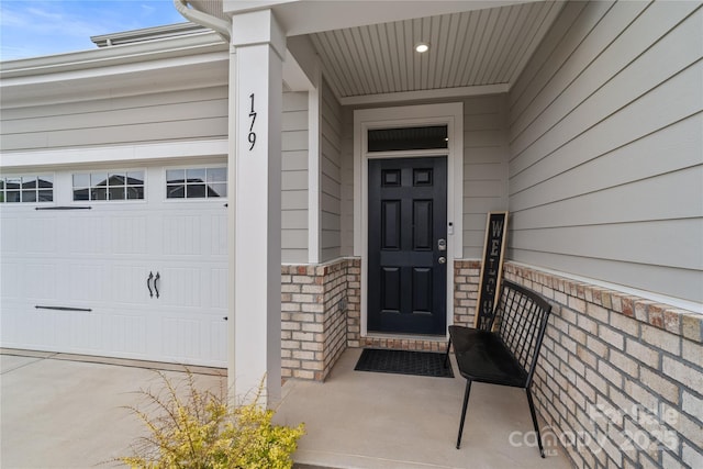 property entrance with an attached garage and stone siding