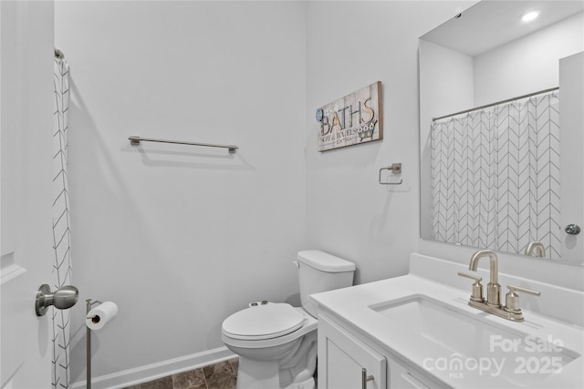 bathroom with toilet, a shower with curtain, vanity, and baseboards