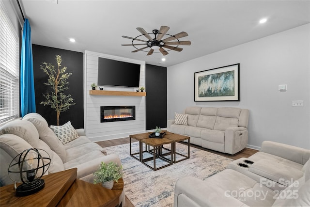 living room with baseboards, a ceiling fan, wood finished floors, and recessed lighting