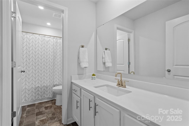 bathroom featuring recessed lighting, stone finish floor, visible vents, toilet, and vanity