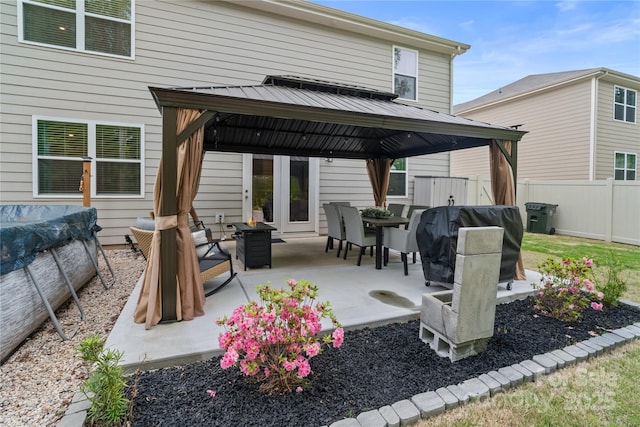 exterior space featuring fence, a standing seam roof, a gazebo, and metal roof