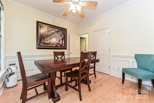 9600 Lockhorn Ct, Mint Hill, NC 28227 - dining space with ornamental molding, light wood-type flooring, ceiling fan, a decorative wall, and wainscoting