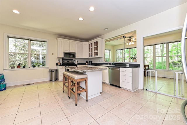 9600 Lockhorn Ct, Mint Hill, NC 28227 - kitchen with appliances with stainless steel finishes, recessed lighting, a sink, a center island, and light tile patterned floors