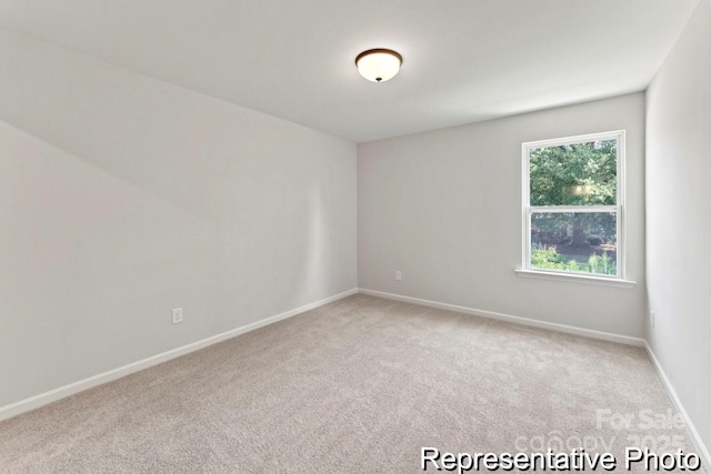 unfurnished room featuring baseboards and carpet