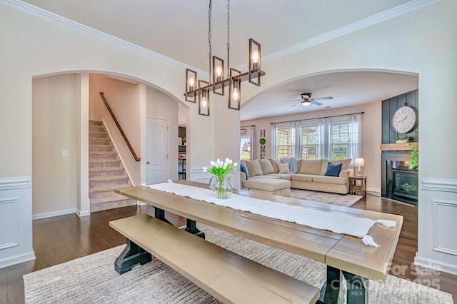 17231 Rider Wood Ln, Charlotte, NC 28278 - dining room with arched walkways, dark wood-style floors, ceiling fan, stairway, and crown molding