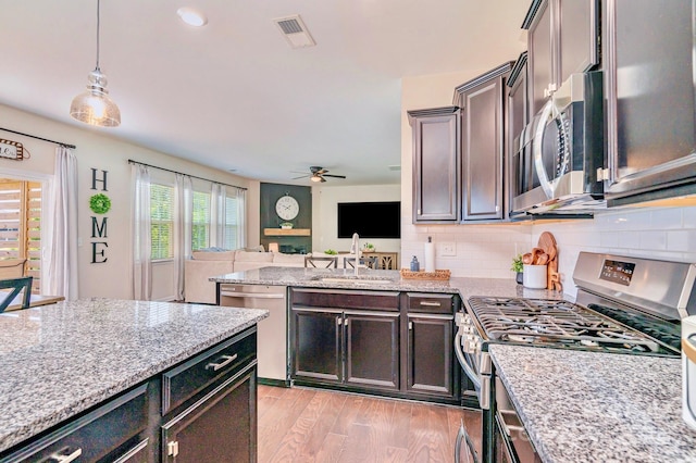 17231 Rider Wood Ln, Charlotte, NC 28278 - kitchen with appliances with stainless steel finishes, a sink, a ceiling fan, open floor plan, and decorative backsplash