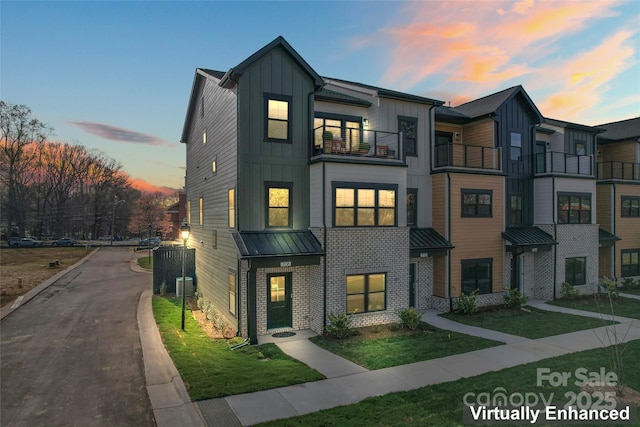 multi unit property with a yard, a balcony, central AC, and board and batten siding