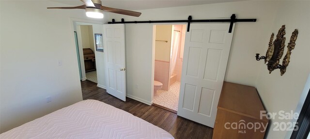 219 Flat Creek Rd, Black Mountain, NC 28711 - bedroom featuring baseboards, a barn door, a ceiling fan, connected bathroom, and dark wood-type flooring