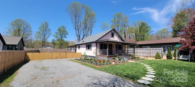 219 Flat Creek Rd, Black Mountain, NC 28711 - view of front of property with a trampoline, covered porch, fence, a front lawn, and gravel driveway