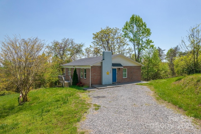 963 Kenham Pl SW, Lenoir, NC 28645 - single story home with gravel driveway, brick siding, a chimney, and a porch