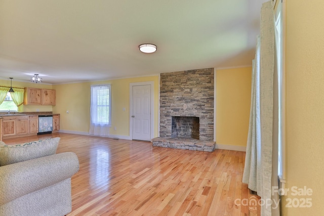 963 Kenham Pl SW, Lenoir, NC 28645 - unfurnished living room featuring light wood-style flooring, crown molding, a sink, and baseboards