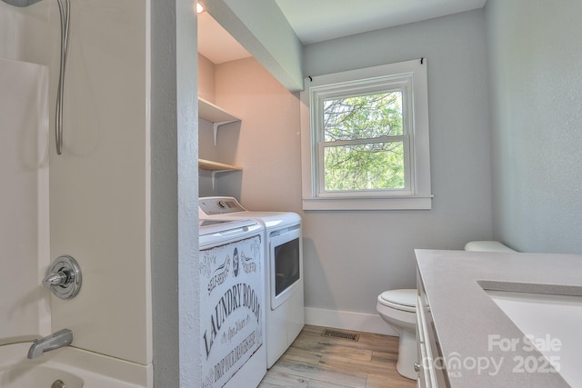 963 Kenham Pl SW, Lenoir, NC 28645 - full bath featuring visible vents, separate washer and dryer, toilet, wood finished floors, and shower / bathtub combination