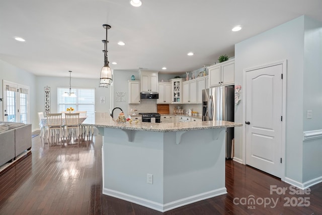 13115 Union Square Dr, Huntersville, NC 28078 - kitchen featuring glass insert cabinets, a breakfast bar, dark wood finished floors, white cabinets, and appliances with stainless steel finishes