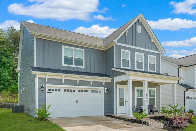 1390 Cedardale Ln, Denver, NC 28037 - view of front of house with board and batten siding, a porch, central AC, concrete driveway, and a garage