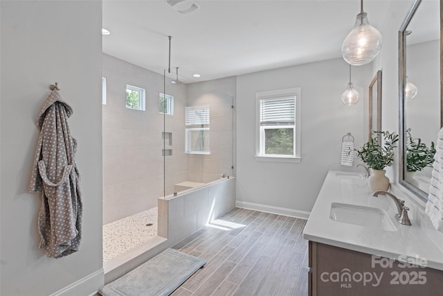 1390 Cedardale Ln, Denver, NC 28037 - bathroom with baseboards, a tile shower, double vanity, wood finished floors, and recessed lighting
