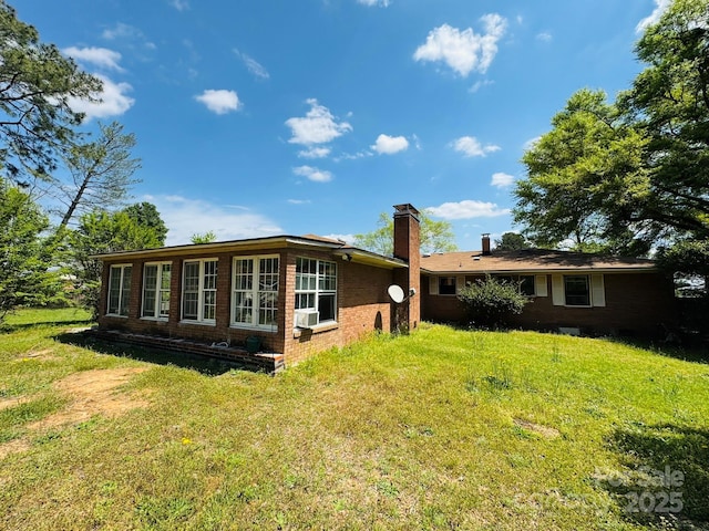 2480 Sumter Hwy, Bishopville, SC 29010 - rear view of house featuring a chimney, brick siding, cooling unit, and a lawn