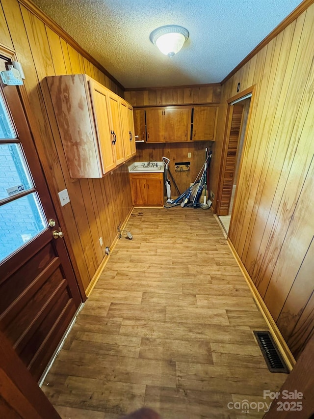 2480 Sumter Hwy, Bishopville, SC 29010 - interior space with a textured ceiling, visible vents, light wood-style floors, wood walls, and ornamental molding