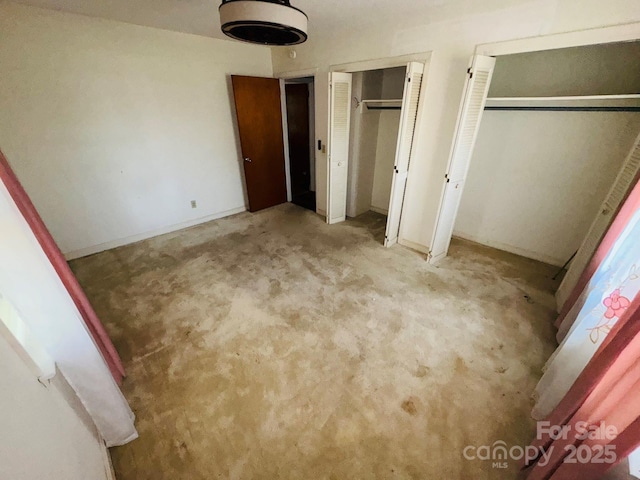2480 Sumter Hwy, Bishopville, SC 29010 - unfurnished bedroom featuring two closets, carpet flooring, and baseboards