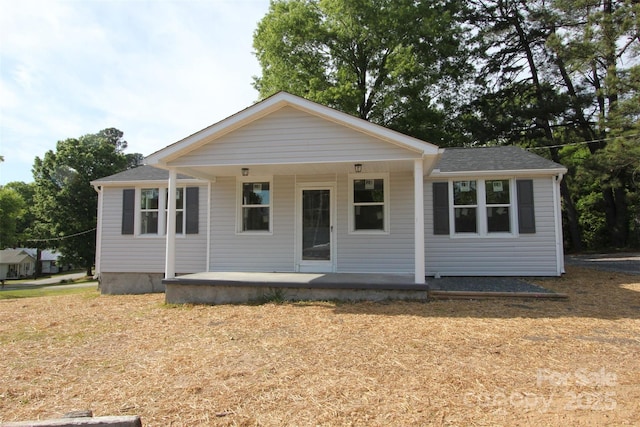 bungalow with covered porch and roof with shingles