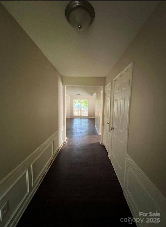 1507 Rumstone Ln, Charlotte, NC 28262 - corridor featuring a decorative wall, a wainscoted wall, and dark wood-type flooring
