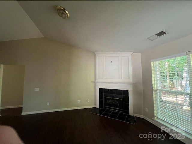 1507 Rumstone Ln, Charlotte, NC 28262 - unfurnished living room with baseboards, a tile fireplace, dark wood finished floors, and lofted ceiling