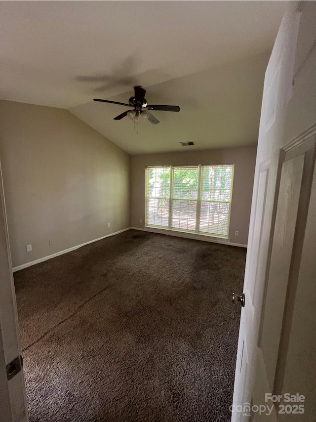 1507 Rumstone Ln, Charlotte, NC 28262 - unfurnished room with vaulted ceiling, a ceiling fan, dark colored carpet, and baseboards