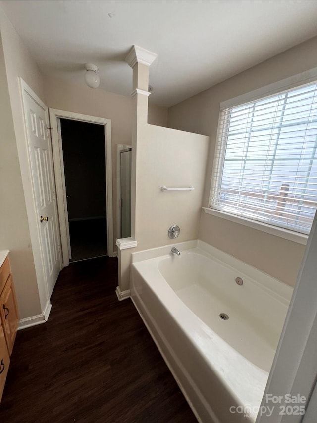 1507 Rumstone Ln, Charlotte, NC 28262 - bathroom featuring wood finished floors, vanity, a garden tub, a stall shower, and baseboards