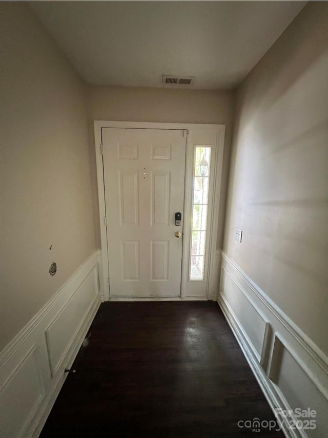 1507 Rumstone Ln, Charlotte, NC 28262 - foyer featuring a decorative wall, wainscoting, and dark wood finished floors