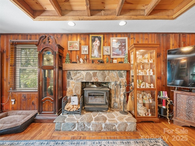 living room with wood ceiling, wood finished floors, wood walls, and a wood stove