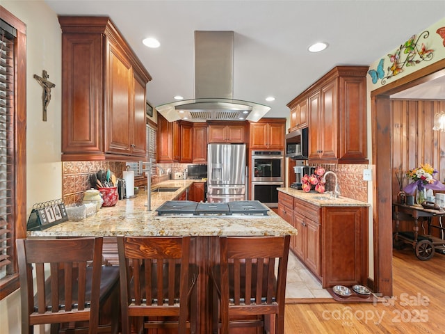 kitchen featuring island range hood, decorative backsplash, a peninsula, appliances with stainless steel finishes, and recessed lighting