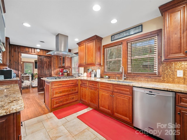 kitchen featuring tasteful backsplash, a sink, island range hood, stainless steel appliances, and a peninsula