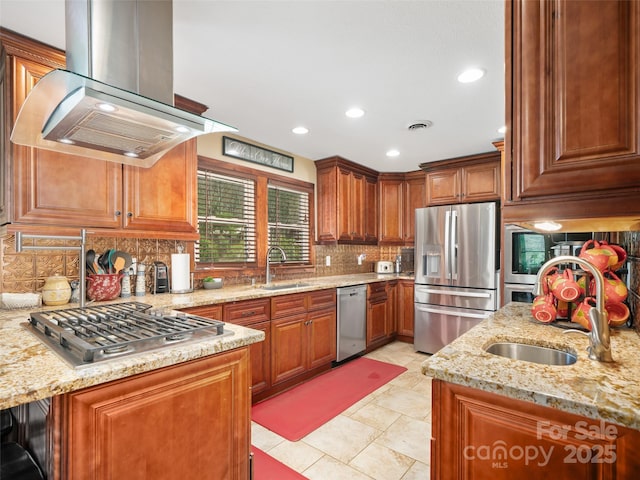 kitchen featuring island range hood, backsplash, stainless steel appliances, and a sink
