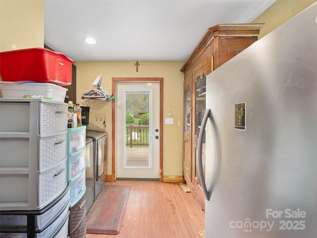 clothes washing area with recessed lighting, wood finished floors, washing machine and dryer, baseboards, and cabinet space