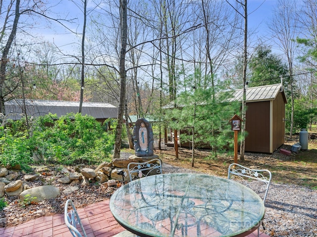 view of yard with a storage unit, an outdoor structure, and outdoor dining space
