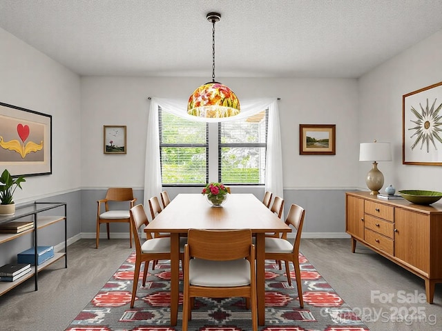 dining area featuring light carpet, baseboards, and a textured ceiling
