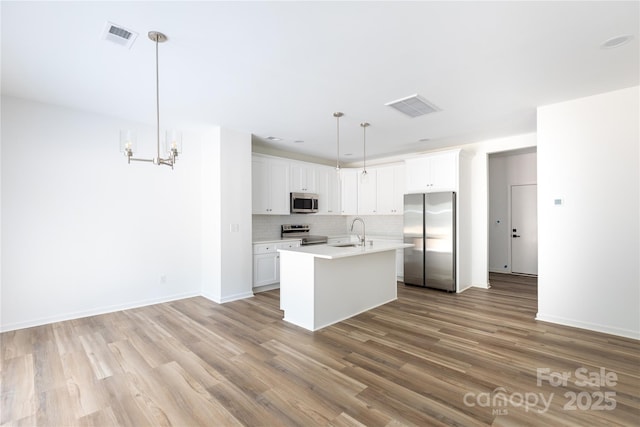 6223 Rockwell Blvd W, Charlotte, NC 28269 - kitchen featuring visible vents, stainless steel appliances, light wood-style flooring, and a sink