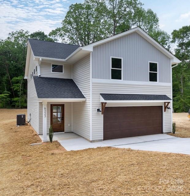 6223 Rockwell Blvd W, Charlotte, NC 28269 - view of front of home with concrete driveway, board and batten siding, a shingled roof, central AC, and a garage